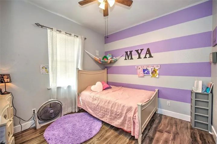 Bedroom with ceiling fan and dark hardwood / wood-style floors