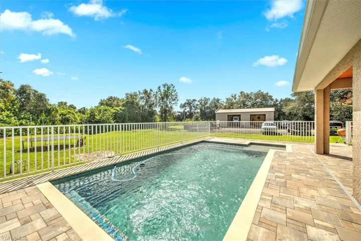 View of pool with a patio and a lawn