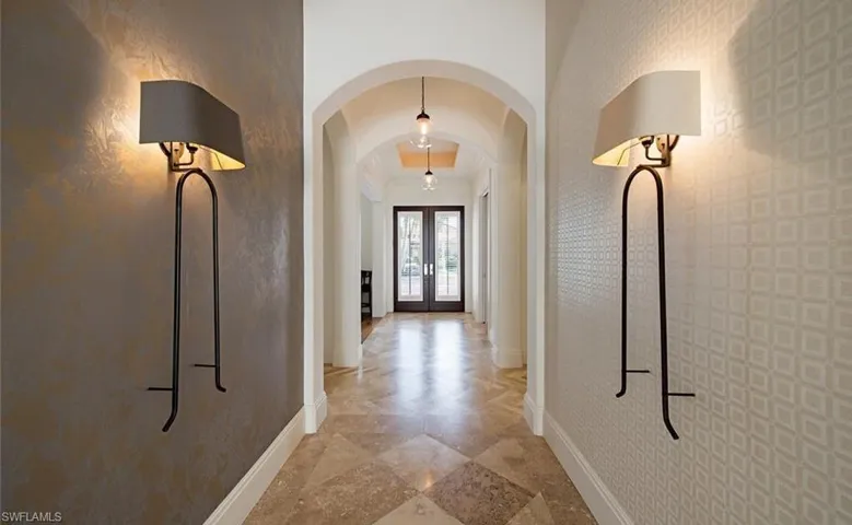 Hallway featuring custom lighting, custom Travertine diagonal flooring, glass entry door, architectural design