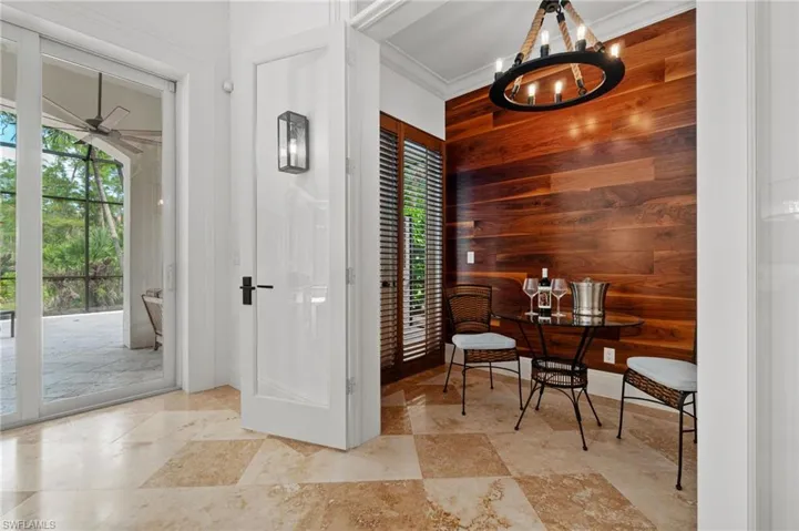 Wine Room/Flex Space featuring hardwood detailing on wall, walnut plantation shutters, custom lighting, dual glass French entry doors