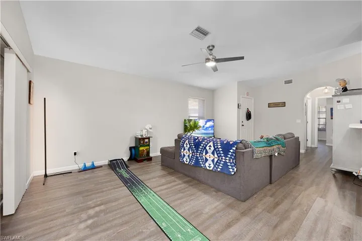 Ranch-style home with roof with shingles, a front yard, stucco siding, concrete driveway, and a sunroom