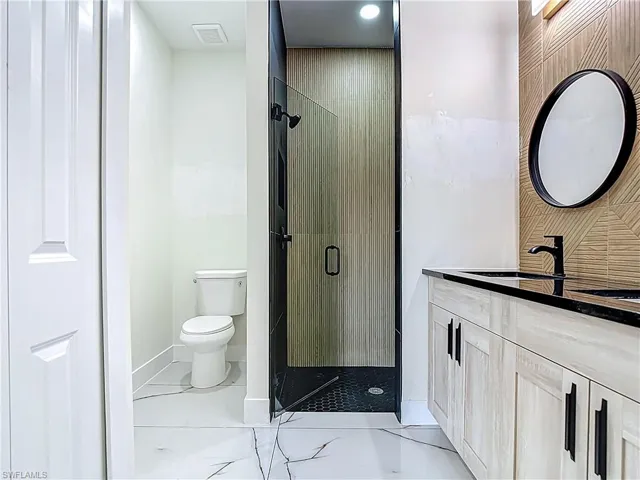 Bathroom featuring vanity and a shower stall