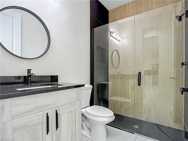 Full bathroom with vanity and a shower stall