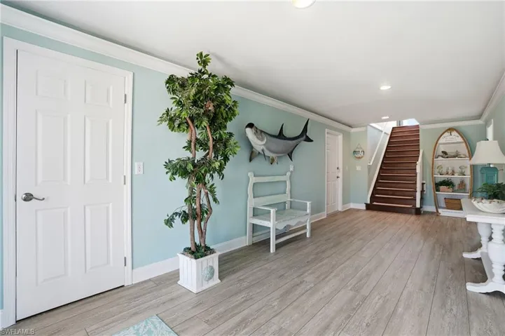 Entrance foyer featuring crown molding, light wood-style flooring, and recessed lighting