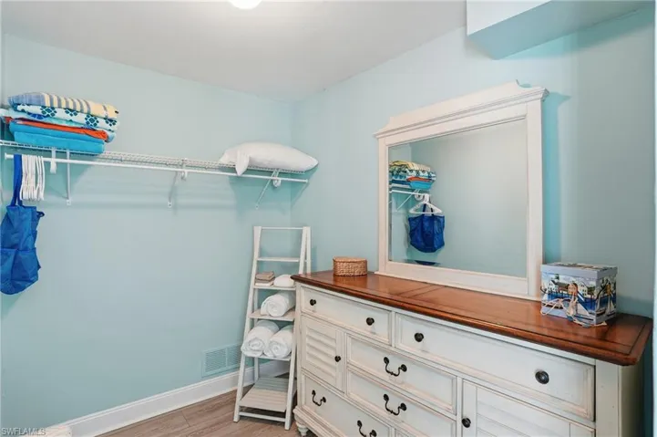 Walk in closet with light wood-style flooring
