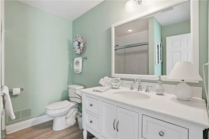 Bathroom featuring vanity, a stall shower, and light wood finished floors