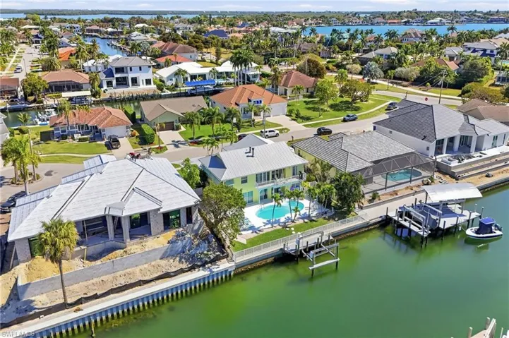Aerial residential area with a large body of water and a pool area