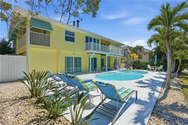 View of pool with a balcony and patio surround