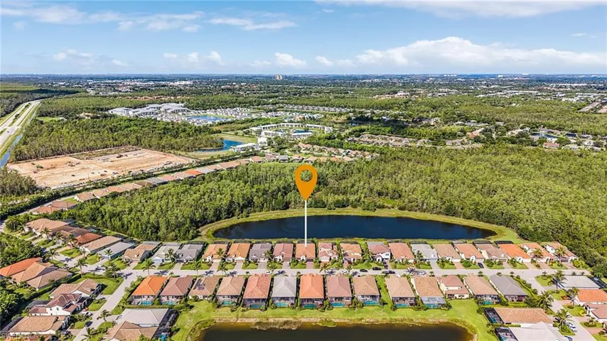 Aerial view of property and surrounding area with a large body of water and nearby suburban area