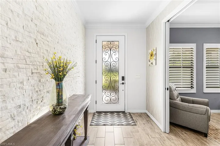 Foyer featuring wood finish floors and ornamental molding