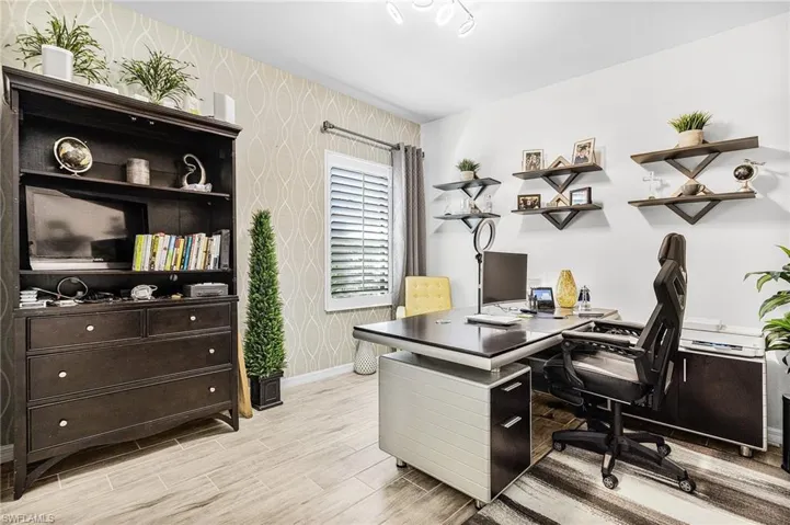 Home office featuring wallpapered walls and light wood-type flooring