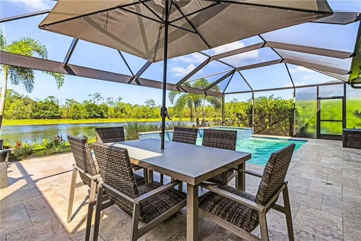 View of patio featuring a water view, an outdoor pool, glass enclosure, and outdoor dining space