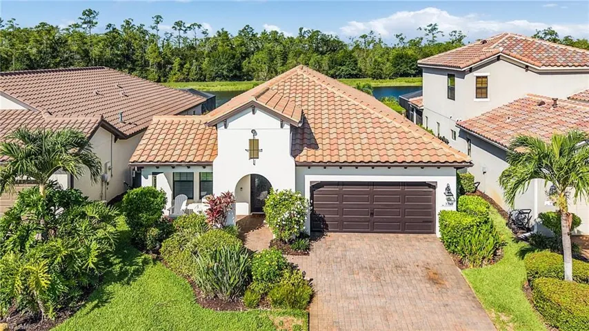 Mediterranean / spanish home with a tiled roof, an attached garage, decorative driveway, and stucco siding