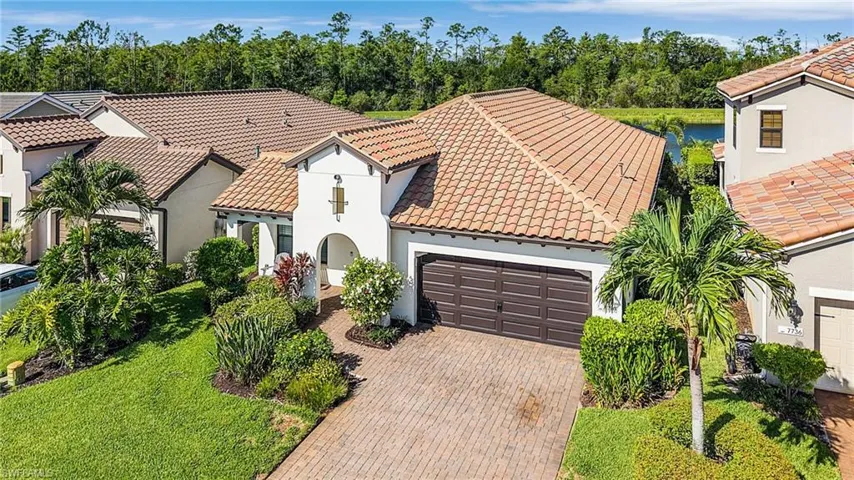 Mediterranean / spanish house with a tiled roof, a garage, stucco siding, and decorative driveway
