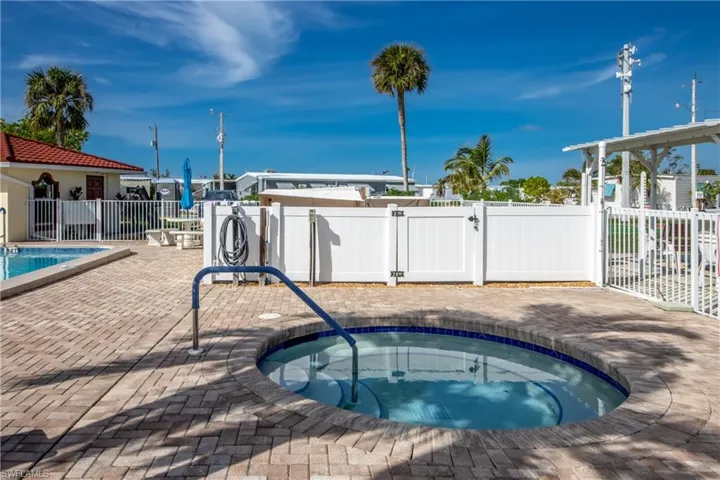View of swimming pool featuring a patio and a hot tub