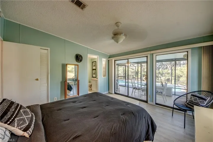 Bedroom with a textured ceiling, access to outside, ceiling fan, light hardwood / wood-style flooring, and a closet