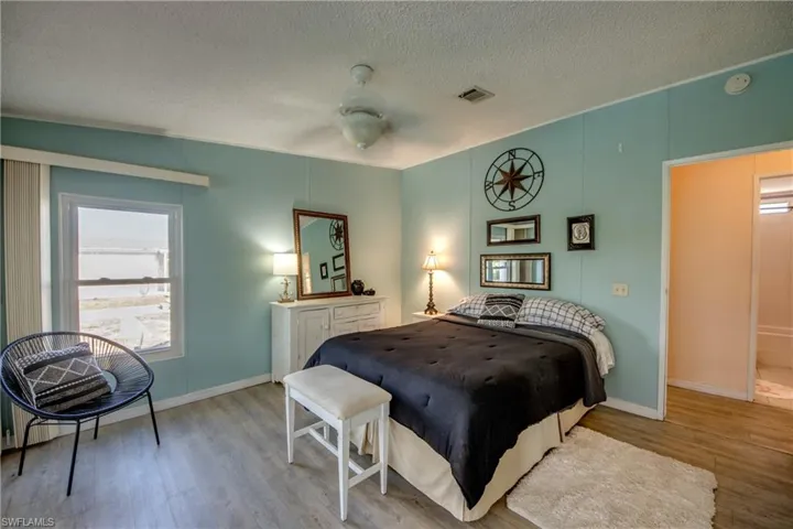 Bedroom featuring ceiling fan, light hardwood / wood-style floors, and a textured ceiling