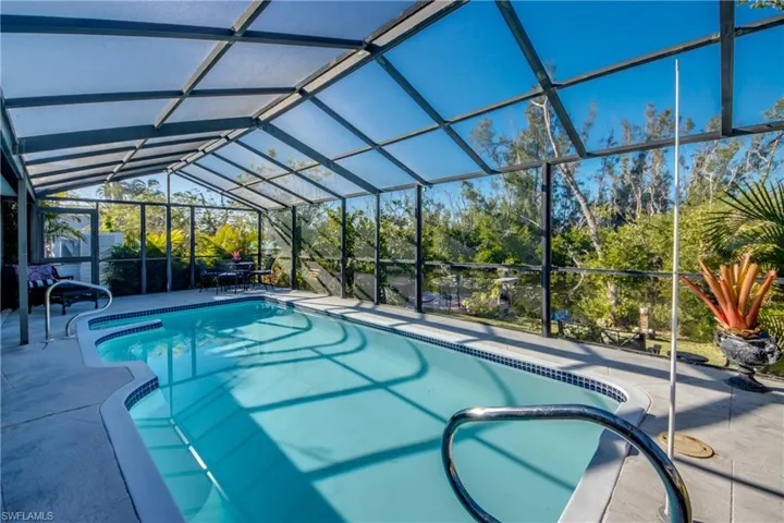 View of swimming pool with glass enclosure and a patio area