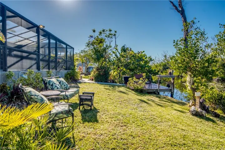View of yard featuring a lanai, a dock, and a water view