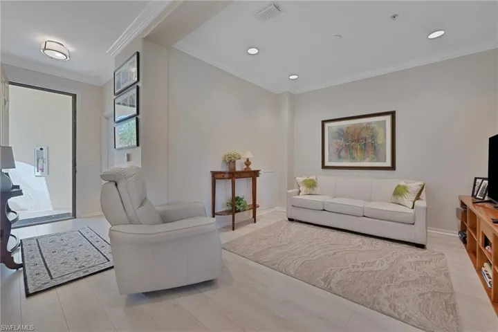 Living area with crown molding and recessed lighting