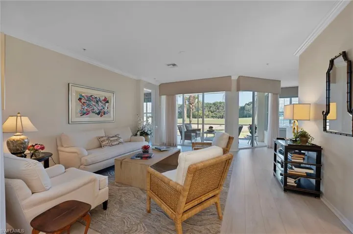 Living area with crown molding and wood finished floors