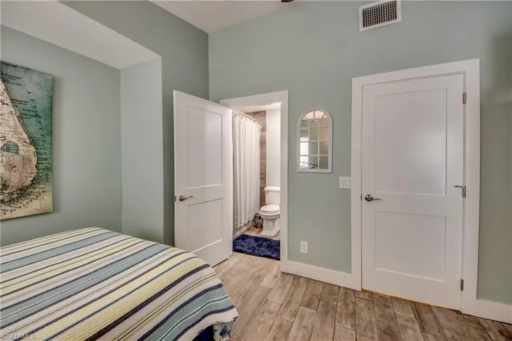 Bedroom with ensuite bath and light hardwood / wood-style flooring