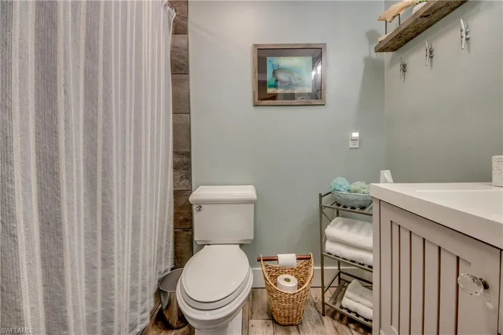 Bathroom with hardwood / wood-style flooring, toilet, and vanity