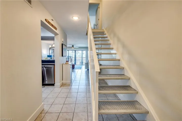 Staircase featuring light tile flooring and ceiling fan