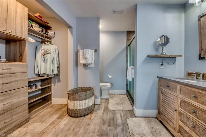 Bathroom with walk in shower, toilet, hardwood / wood-style flooring, and vanity