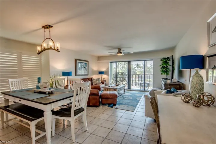 Tiled dining space with ceiling fan with notable chandelier
