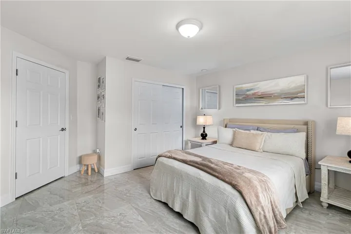 Bedroom featuring light marble finish flooring and a closet