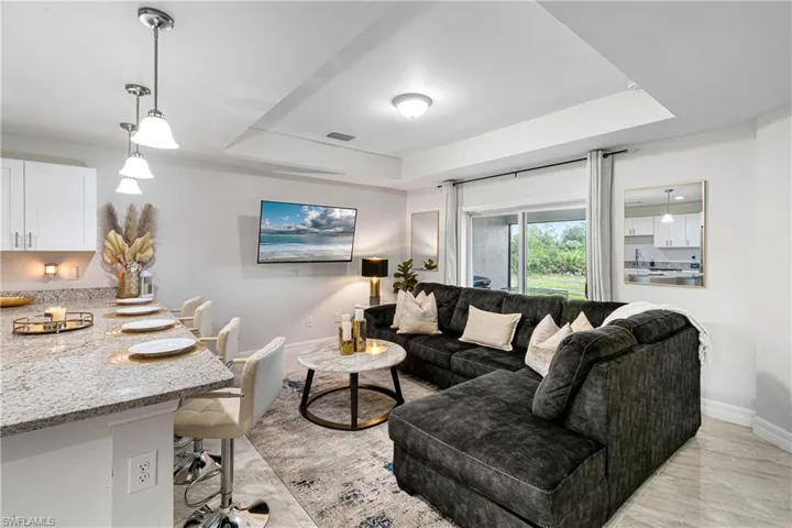 Living area with a raised ceiling and baseboards