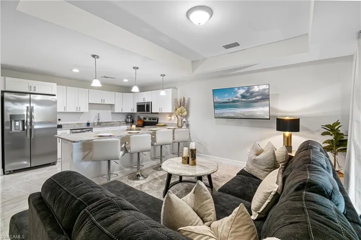 Living room with recessed lighting and a tray ceiling