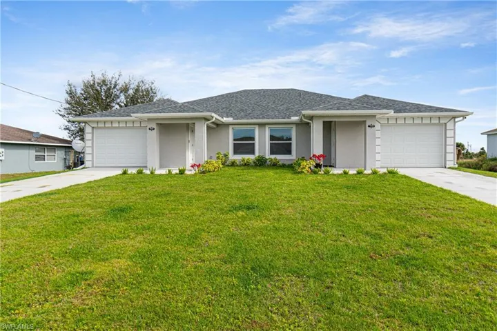 View of front facade featuring a front yard, driveway, roof with shingles, and a garage