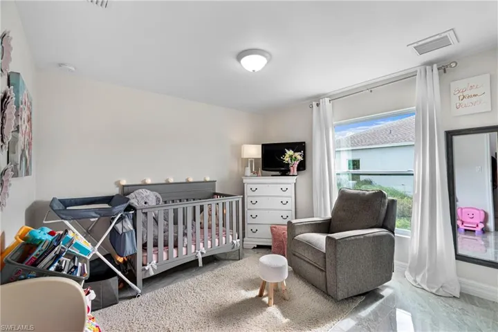 Bedroom featuring a crib and baseboards