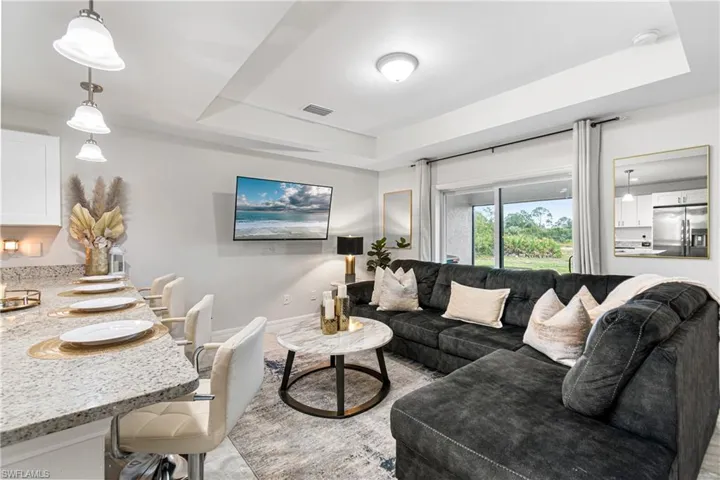 Living room featuring a raised ceiling and baseboards
