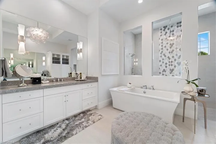 Bathroom featuring separate shower and tub and vanity