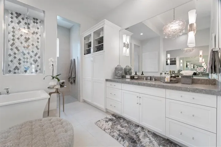 Bathroom with tile patterned flooring, vanity, and a bathing tub