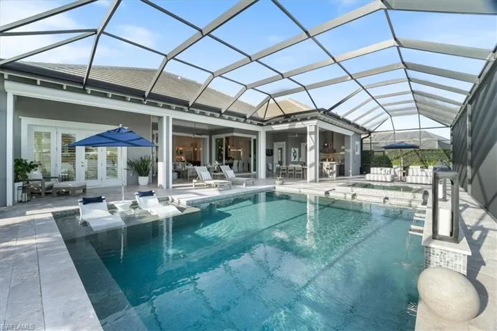 View of swimming pool with a lanai, a patio area, ceiling fan, and french doors