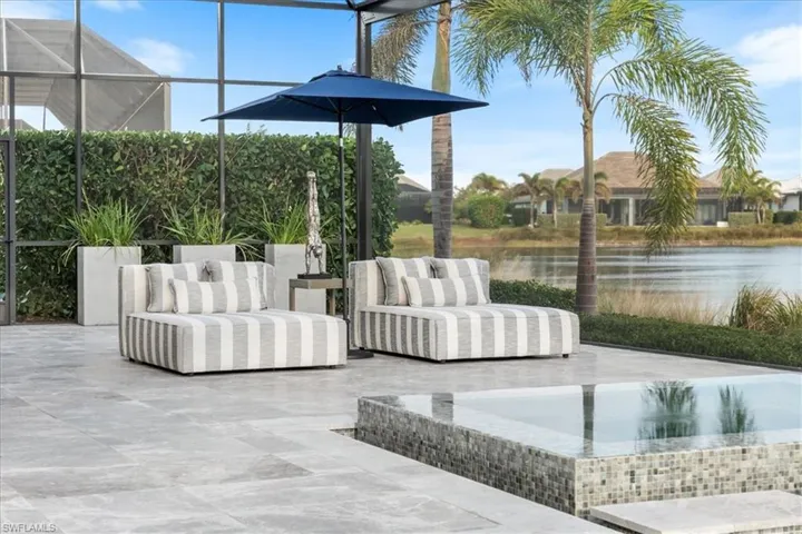 View of patio / terrace featuring an outdoor living space, a water view, and a hot tub
