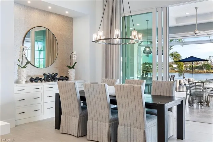 Tiled dining space featuring ceiling fan with notable chandelier