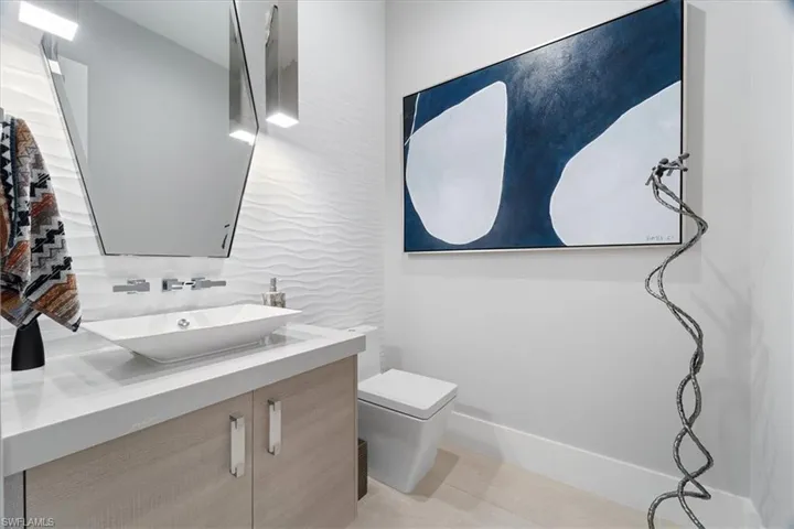 Bathroom with vanity, toilet, and backsplash