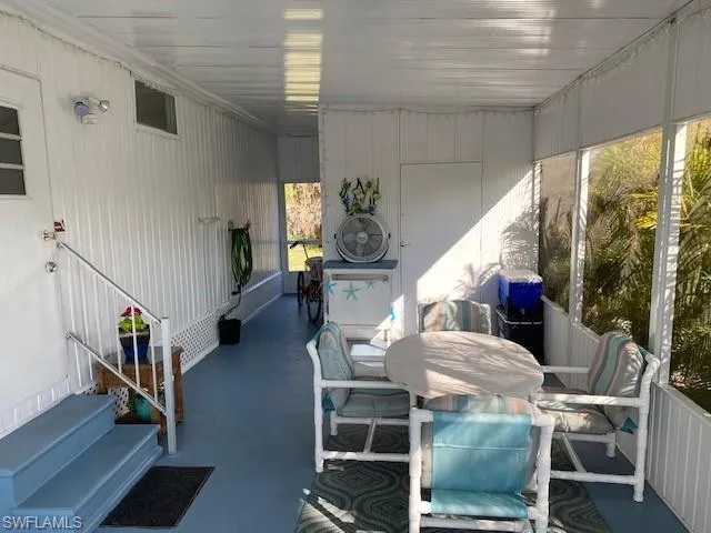 Sunroom featuring outdoor dining space, entry steps, and a patio area