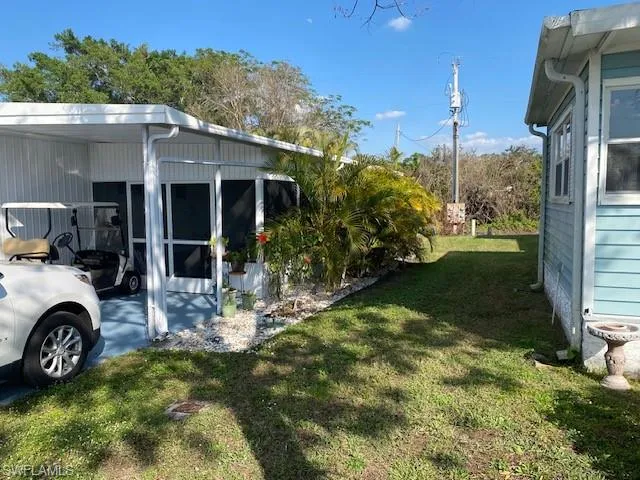 View of grassy yard featuring a sunroom