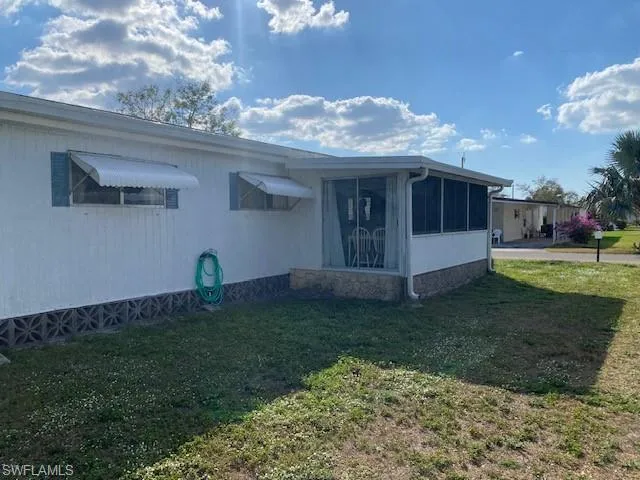 View of front facade with a sunroom and a front yard