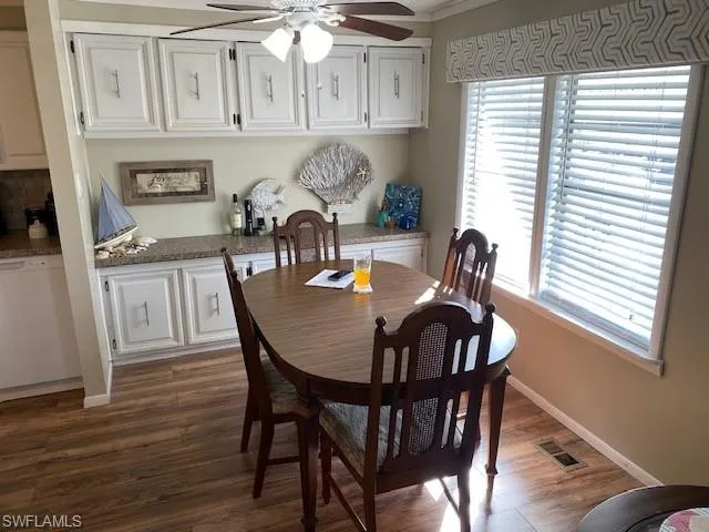 Dining area with ceiling fan and dark wood-type flooring