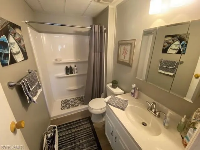 Full bathroom featuring vanity, a shower stall, and dark wood finished floors