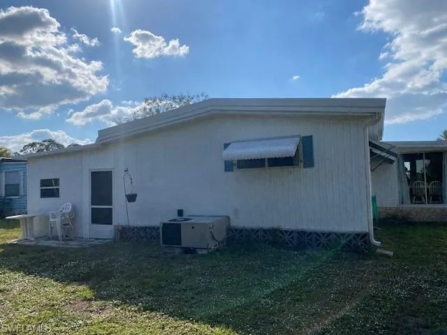 Back of property featuring a lawn and a patio area