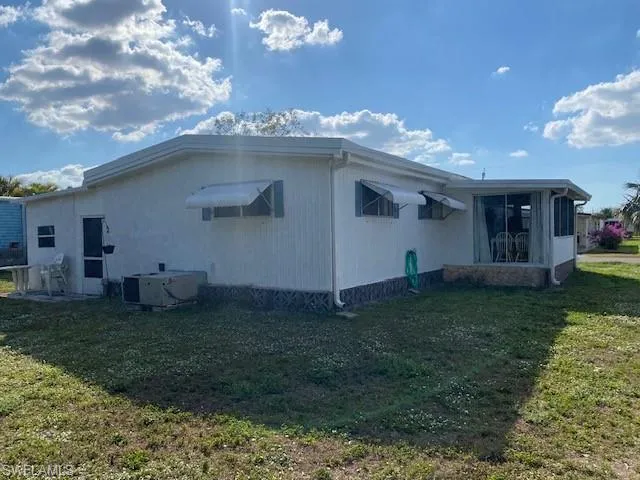 View of property exterior featuring a yard and a sunroom