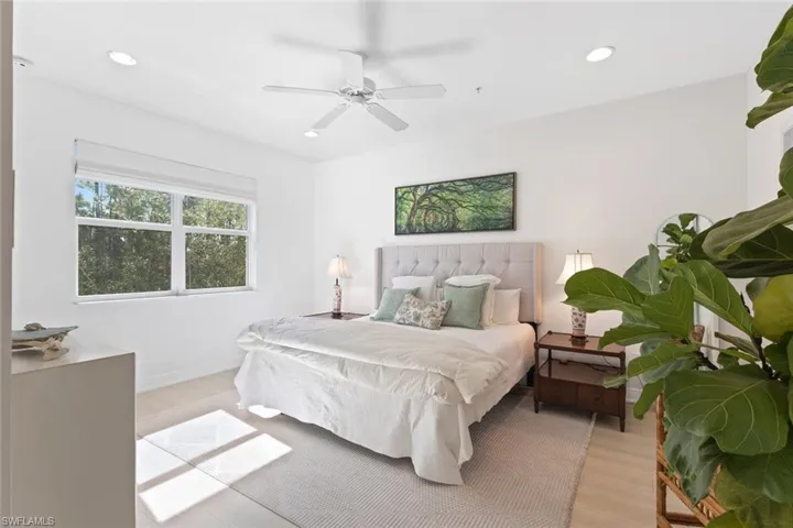 Bedroom with light wood-style floors, ceiling fan, and recessed lighting